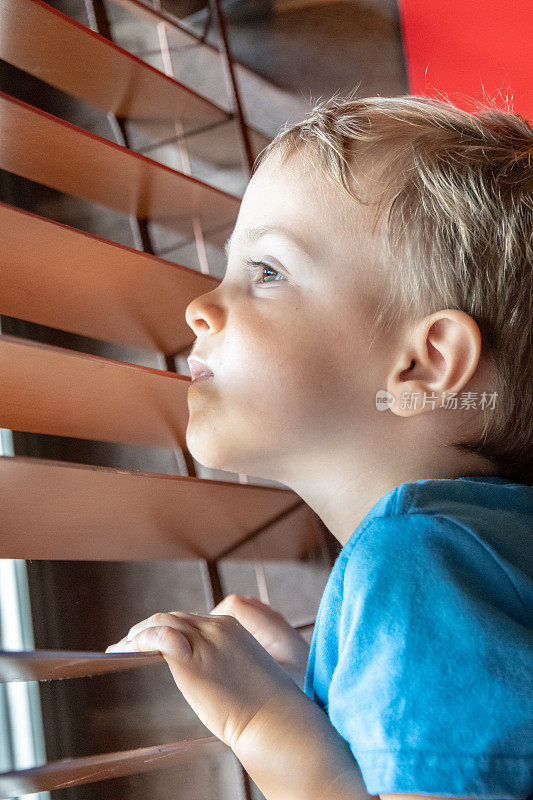 一个三岁的小男孩往窗外看