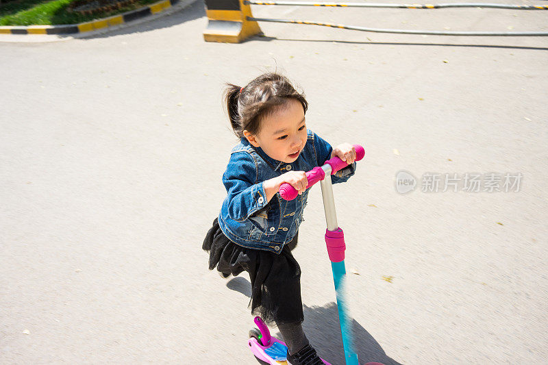 一个小女孩在玩滑板车