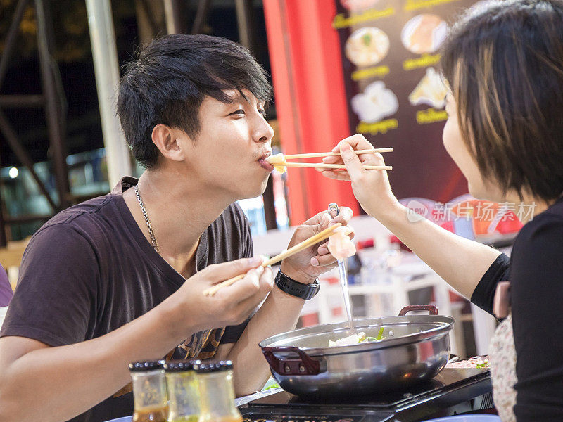 亚洲夫妇一起在餐厅享用涮锅。