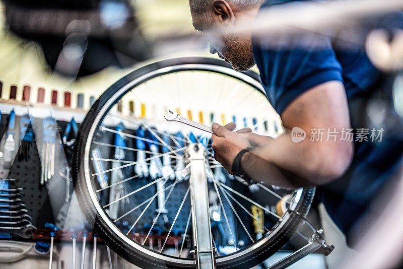 自行车修理工在车间修理一个自行车轮子。