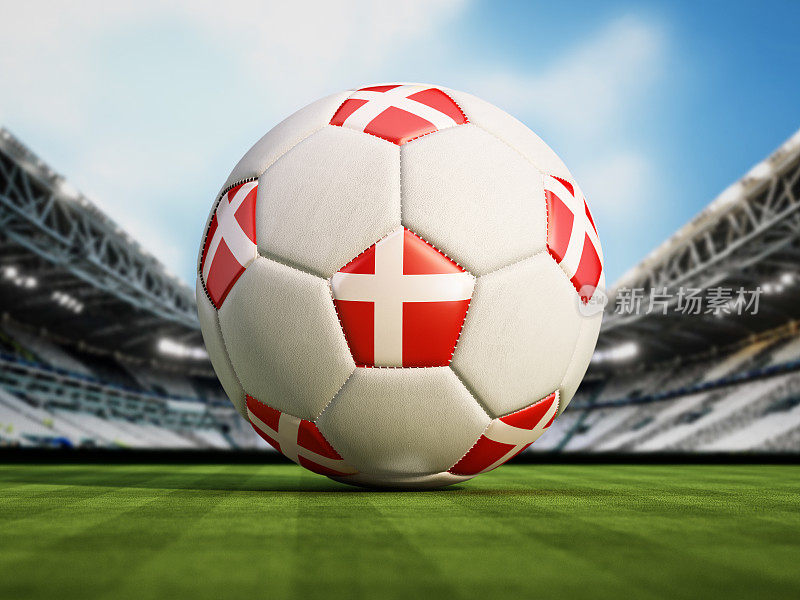 绿色足球场上的足球上立着丹麦国旗