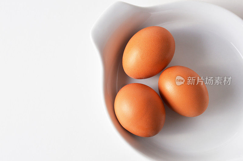 三个鸡蛋在一个白盘子里