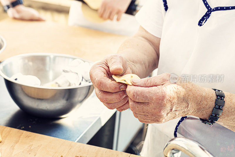 这位老妇人用手包饺子