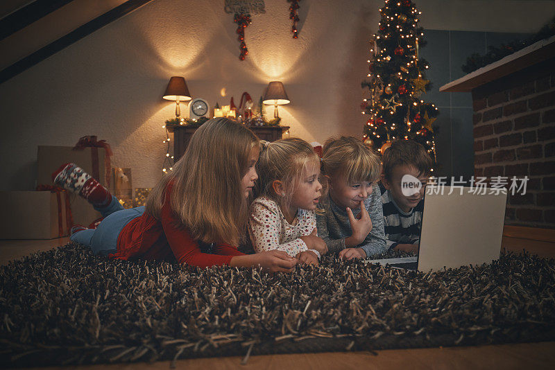 在舒适的圣诞气氛中，孩子们在客厅里拿着笔记本