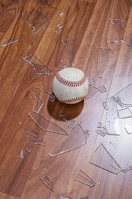 从地板上的一扇窗户往下看一个有碎玻璃的棒球