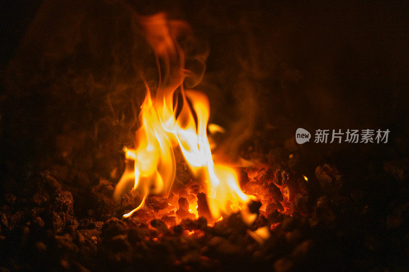 彩色的火焰从一个炽热的煤火在壁炉靠近