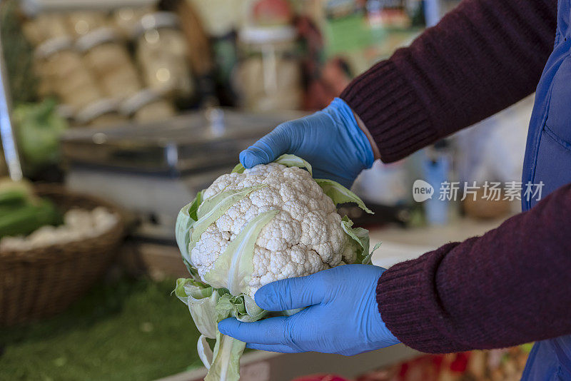 戴着橡胶手套的蔬菜水果商。