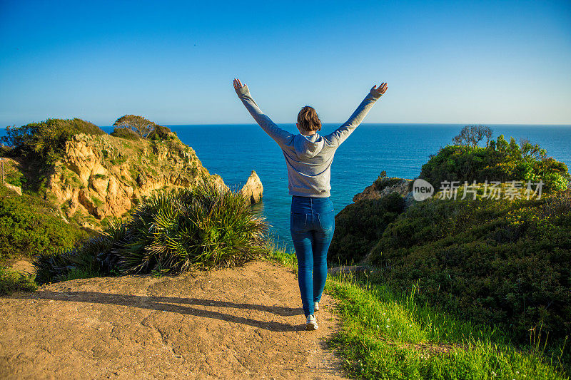 年轻的黑发女性享受她的自由在阿尔沃葡萄牙在夏末的阳光海滨