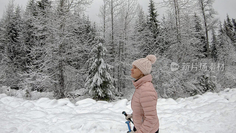 女性徒步旅行者沿着雪道行走