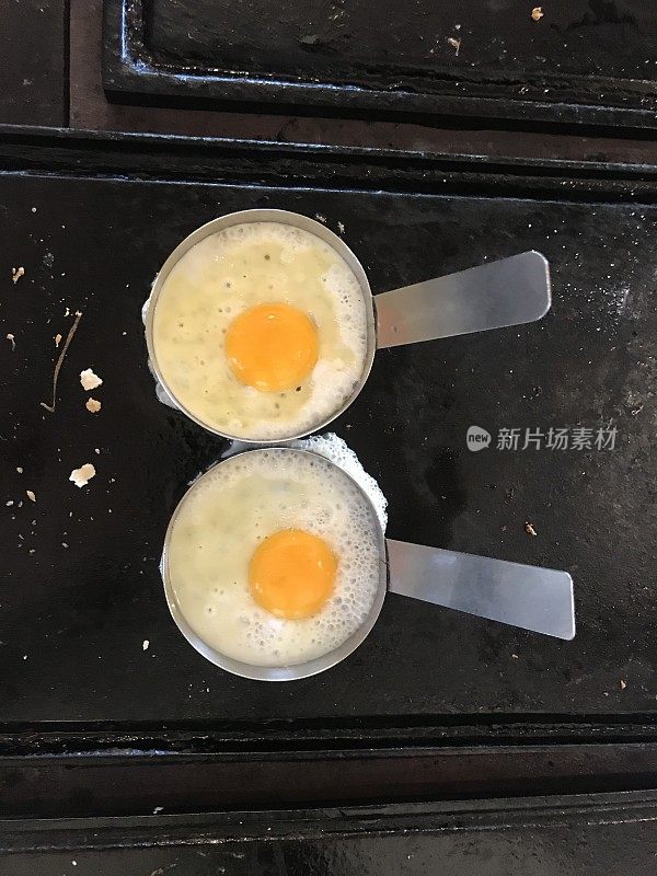 两个鸡蛋放在一个旧炉子的金属片里――乡村食物