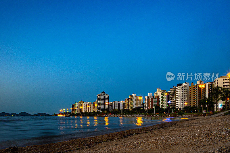 在Florianópolis，贝鲁特北路的日落景观，在海上被照亮的建筑物的倒影。