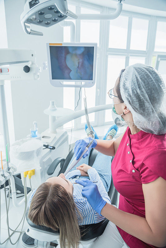 牙医在牙科诊所的接待处检查病人。医疗设施中的保健和治疗概念