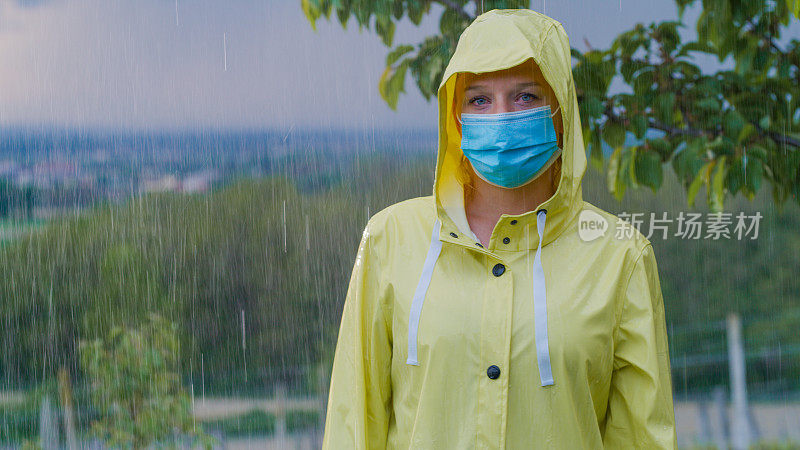 雨点落在一个穿着雨衣戴着面具的女人身上