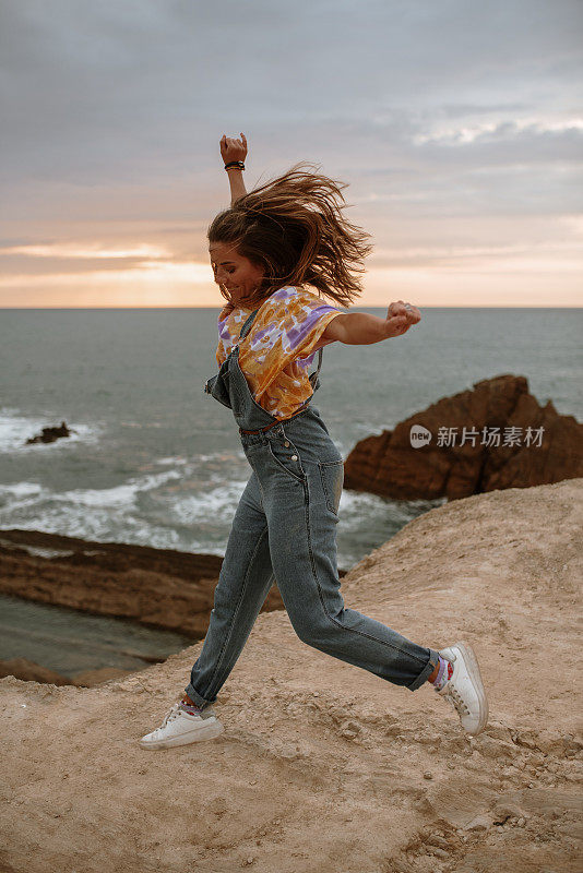 年轻女子在海边蹦蹦跳跳