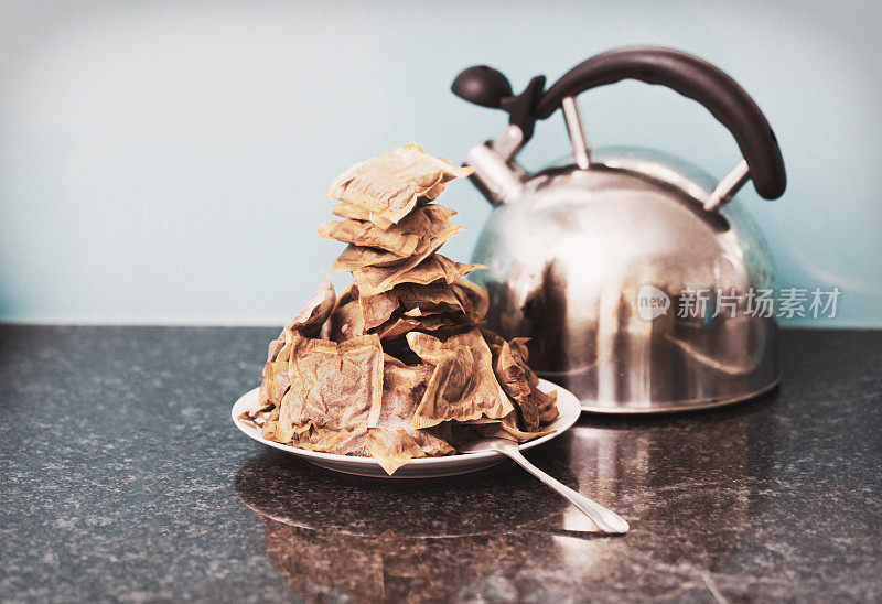 由一群爱茶的人制作的高得吓人的茶包，旁边是铬茶壶