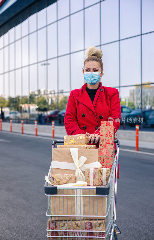 2019冠状病毒病大流行期间，一名年轻女性在圣诞节购物时戴着防护口罩