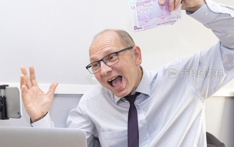 一名白种人手里拿着一捆捆的钞票，兴高采烈。喜悦和情绪。
