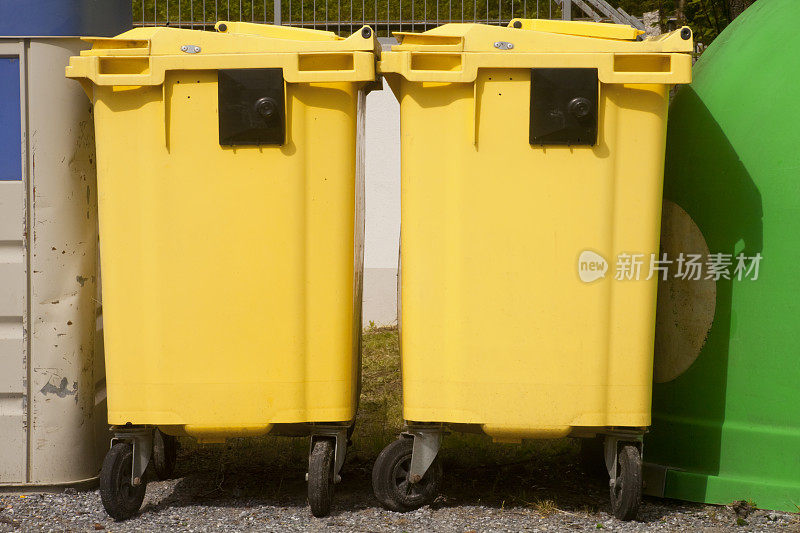 两个黄色垃圾桶用于回收。