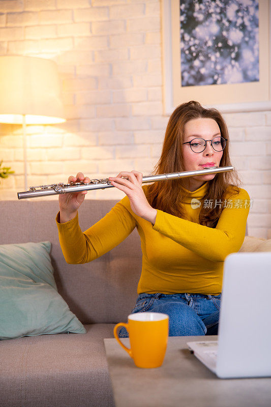 一名女子正在教一个在线课程如何在家弹奏一种乐器。