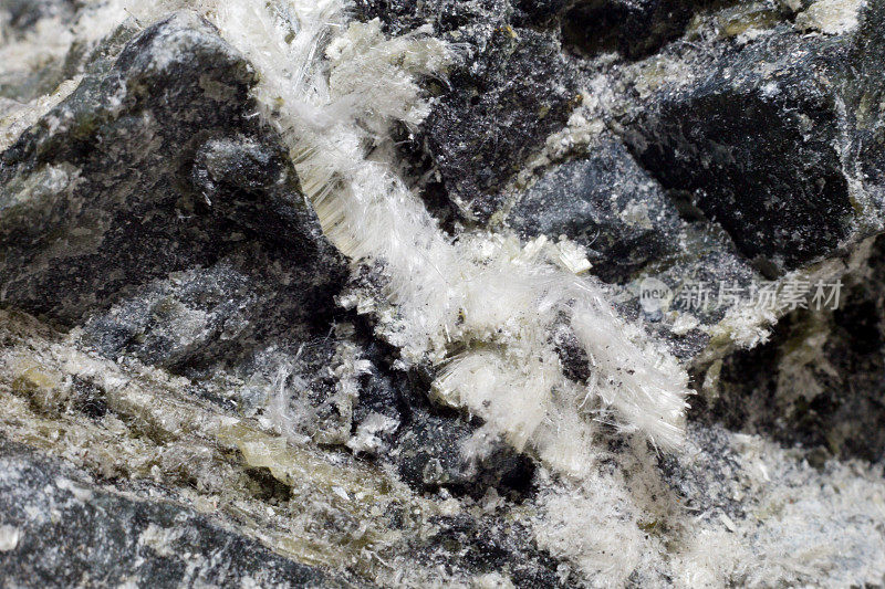 石头中石棉矿物的白色纤维，特写。