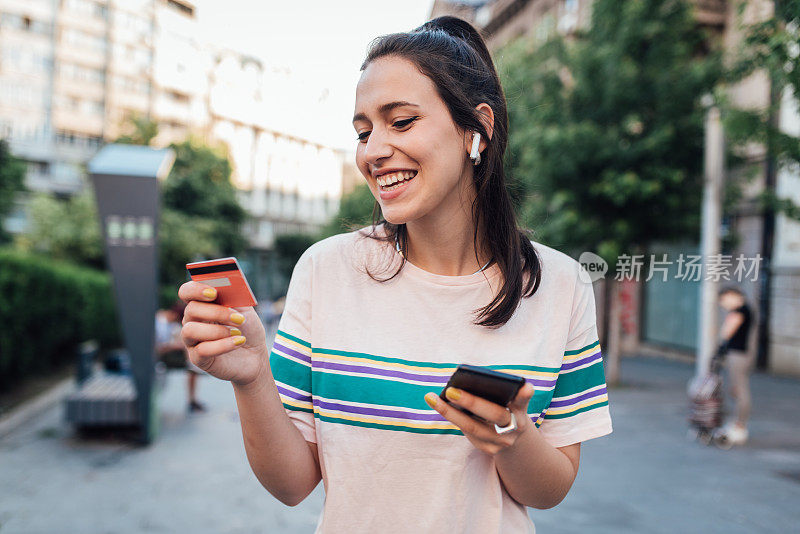 拿着信用卡在网上购物的女孩