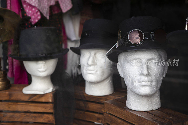 商店橱窗里三个戴着帽子的聚苯乙烯头模型