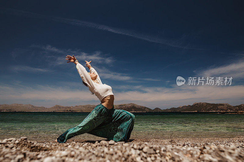 年轻灵性的女人在阳光明媚的海滩上跳着灵性和神圣的舞蹈