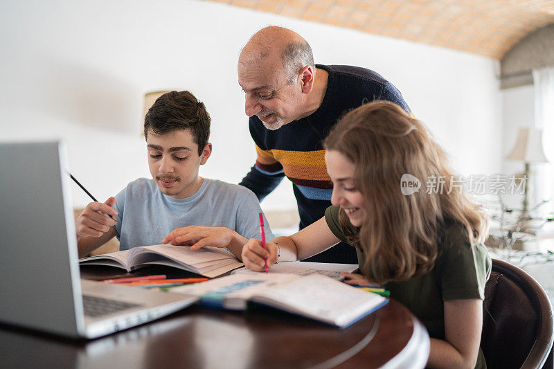 父亲在家帮儿子和女儿做作业