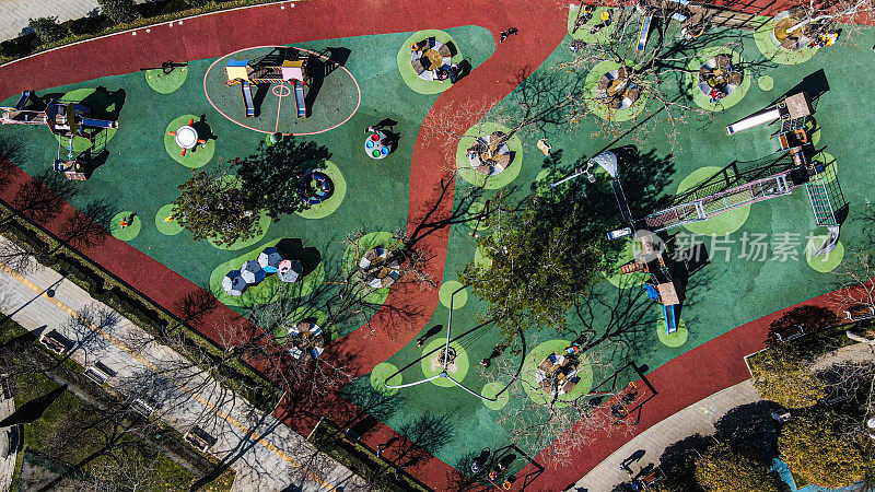 空中儿童游乐场，秋千和滑梯，快乐的孩子，在公园里玩耍的孩子和他们的家人，城市里的大公园