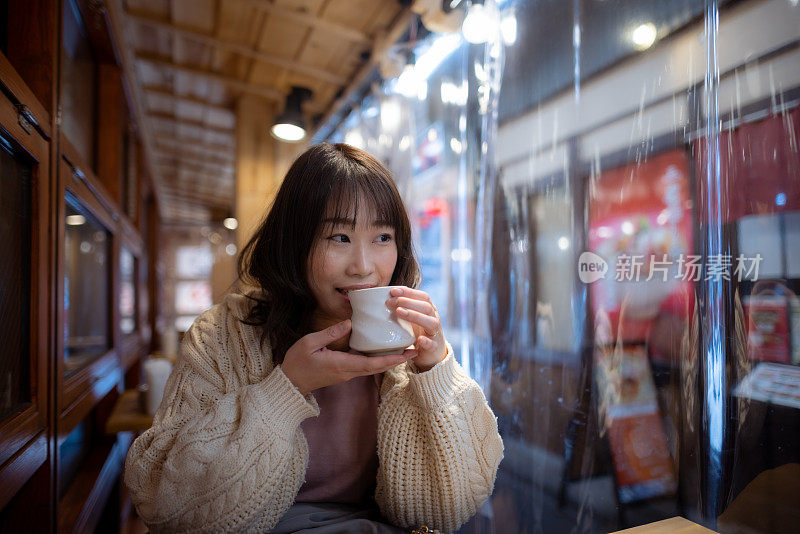 女子在户外餐厅喝着一杯日本茶