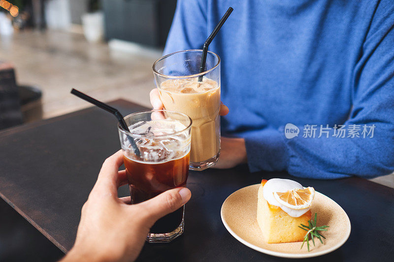 咖啡桌上一对夫妇用柠檬蛋糕碰咖啡杯的特写