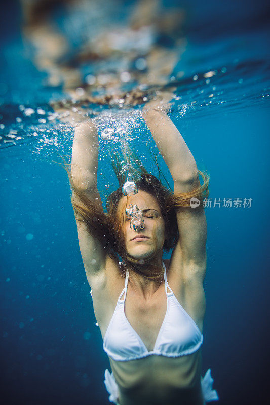 迷人的年轻女子在海里潜水