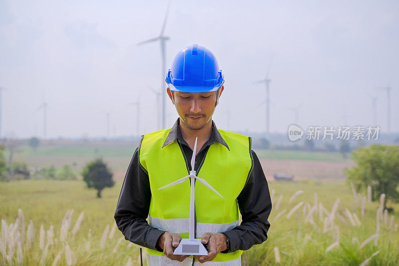 在发电厂工作的蓝领工人。风车。