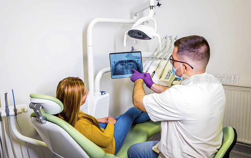 牙科医生向病人讲解x光影像