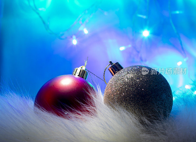 圣诞节灯泡。金色和红色球圣诞装饰上的光，蓝色的背景。