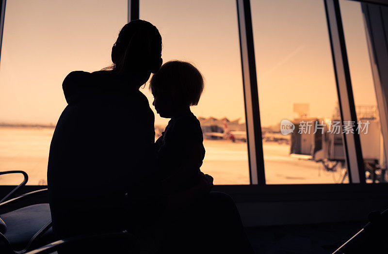 母亲和儿子在机场等待他们的航班。等待航班。