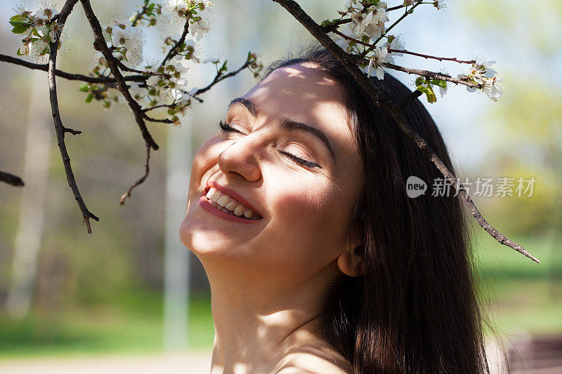 闻着花的美丽年轻女子