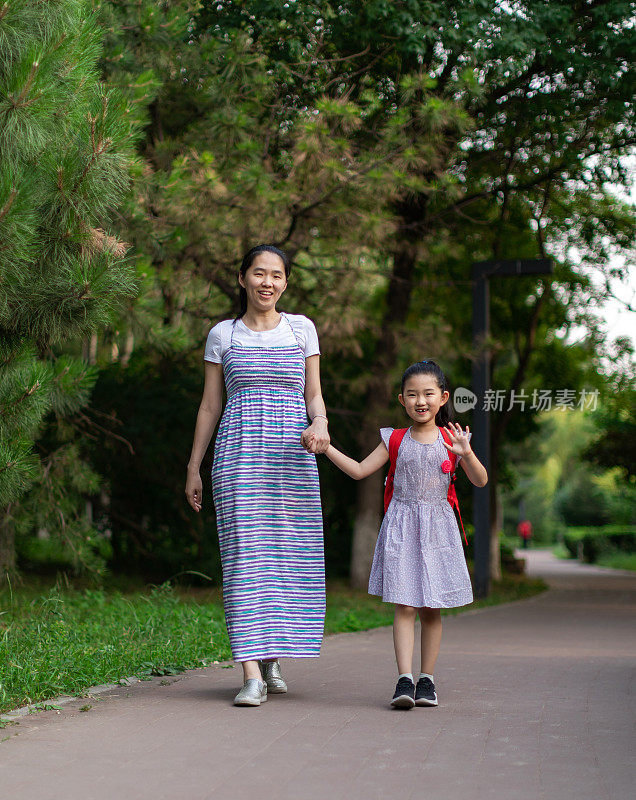 母亲领着女儿去学校