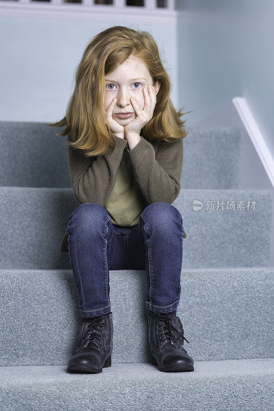 奥本头发的小女孩坐在楼梯上
