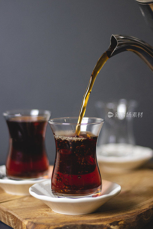 土耳其茶，一杯泡好的土耳其红茶从茶壶中倒出，传统热饮概念
