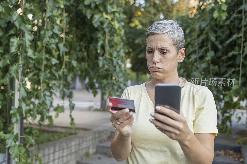 一位女士正专注于通过智能手机网购