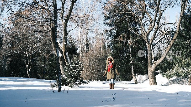 兴高采烈的女游客在冬季公园玩雪