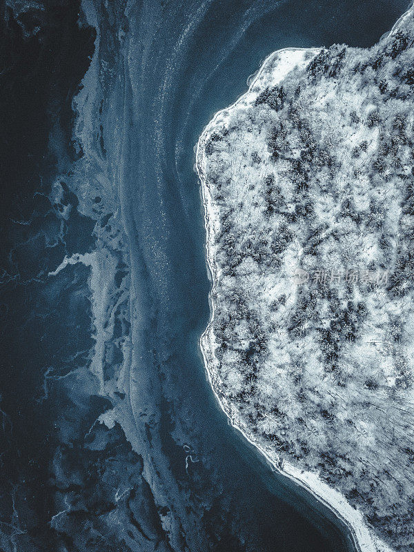 德国巴伐利亚州Sylvensteinsee冬季鸟瞰图。这个冰冻的湖泊部分被冰雪覆盖，而无人机拍摄到的其他地方可以看到清澈的蓝色湖水