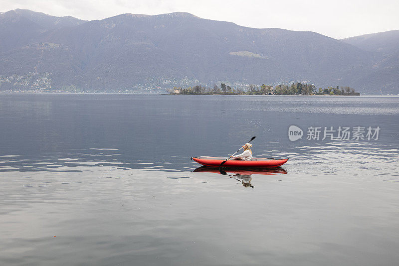 在平静的湖面上划独木舟的女人