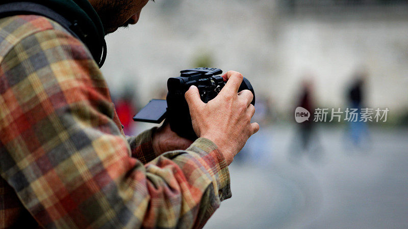 电影制作人捕捉城市景观，男子手持相机拍摄视频，摄影师拍摄户外视频，游客拍摄伊斯坦布尔城市