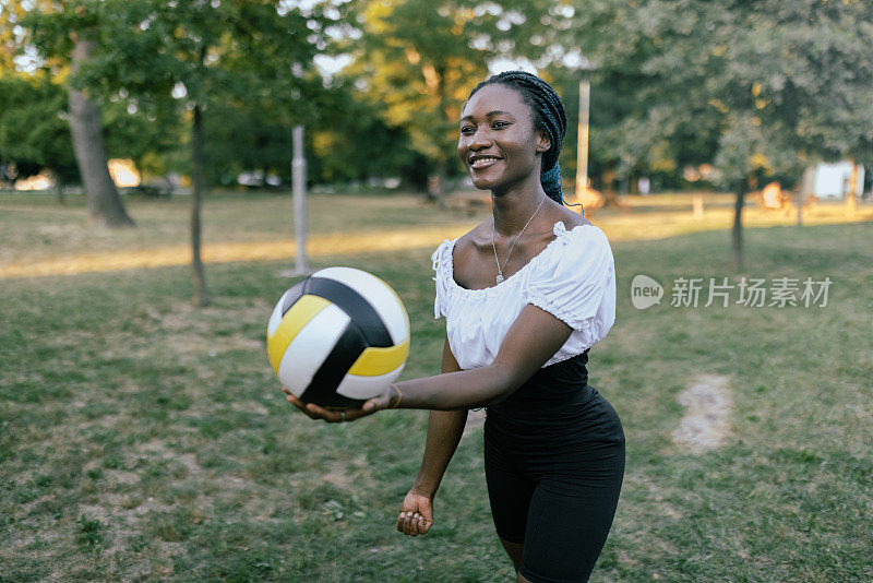 一个年轻的非洲妇女在大自然中打排球比赛的照片。