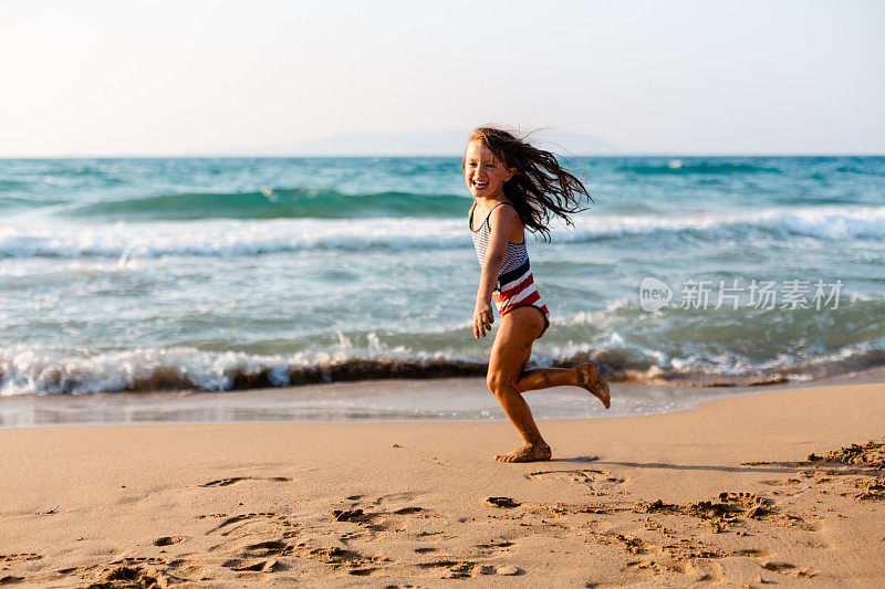 活泼的小女孩在沙滩上奔跑