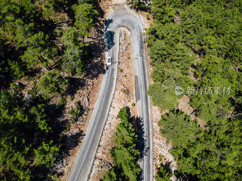 在森林山区的道路上行驶的车辆用无人机拍摄沥青弯道