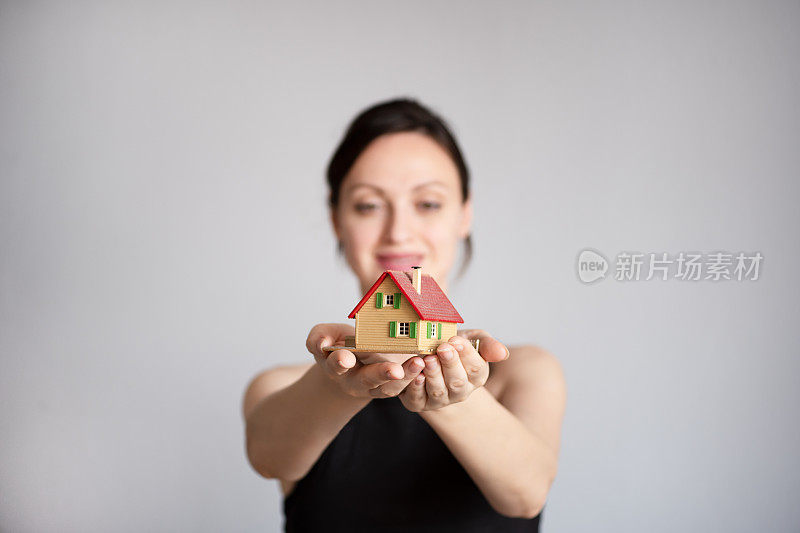 手持房屋或家庭模型的女性