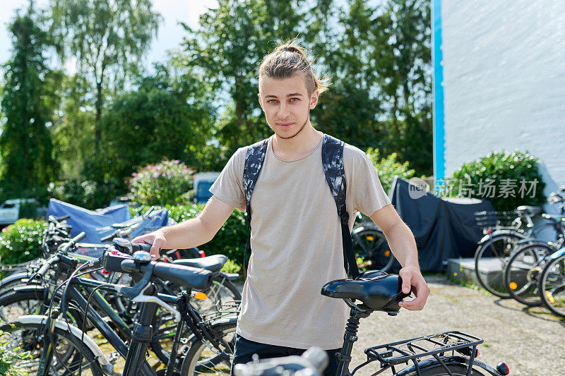 一个背着双肩包和自行车的大学生，有教育背景